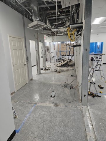 Professional flooring transition between two materials in a commercial retail space with clean, seamless lines.