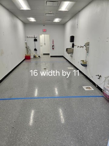 Organized 16x11 utility room featuring wall-mounted shelving and a clean technical repair workspace.
